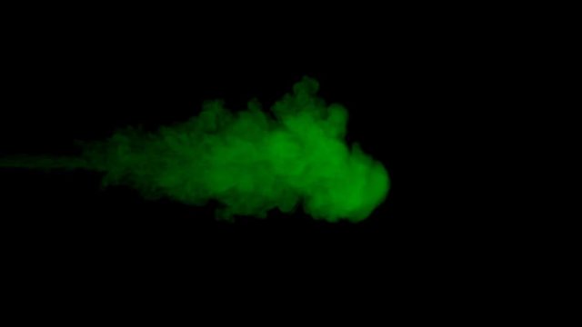 Amorphous cloud of green ink dispersing in water in a creative abstract design over a dark background showing the diffusion of the liquids