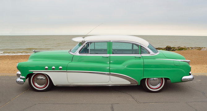  Classic Green and White American Motor Car parked on seafront promenade.