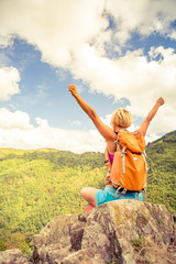 Hiking woman celebrating inspirational mountains landscape