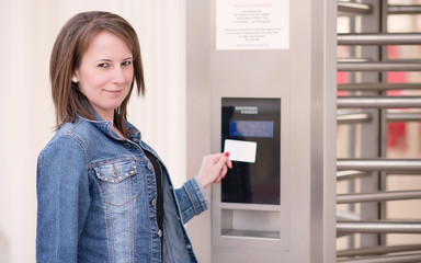 Young woman puts the card into the reader system