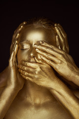 Fototapeta na wymiar Girl painted gold. 6 hands on your face: see no evil,hear no evil, speak no evil.