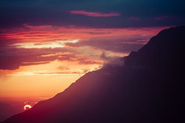 Sun setting behind a mountain. Orange landscape of Himalayas, Nepal