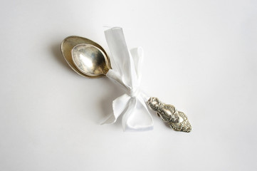 A set of silver spoons tied with ribbon on light background