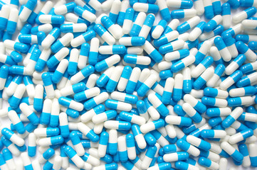 blue and white pill capsules background. Close-up