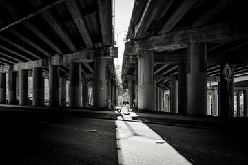 Runner casting shadow underneath the freeway