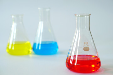 Laboratory glass Erlenmeyer conical flask filled with chemical liquid for a chemistry experiment in a science research lab and copy space.