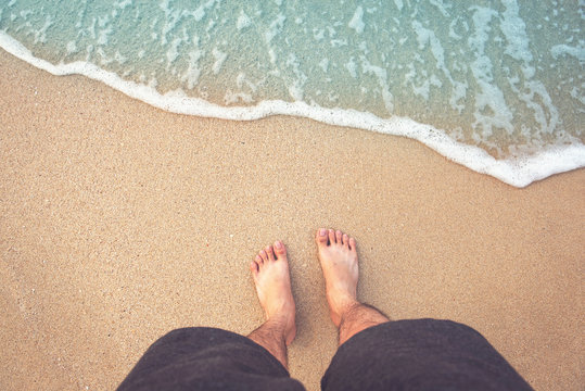 Feet on sea sand and wave, Vacation on ocean beach, Summer holiday.