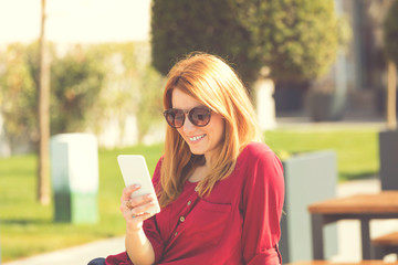 Pretty woman using her cellphone outdoors.