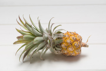 Pineapple shelled Asian-style on the white wooden background. Tropical fruit concept