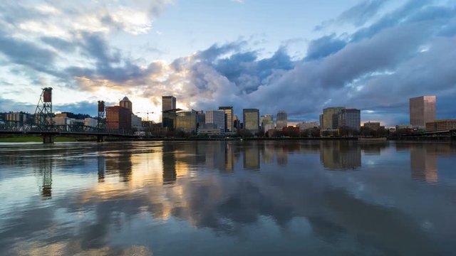Dramatic clouds and sky moving over downtown Portland Oregon with water reflection along Willamette River waterfront at sunset into blue hour 4096x2304 4k ultra high definition time lapse