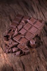 Chocolate bar pieces. large bar of chocolate on wooden background. Slices of chocolate Sweet food photo concept