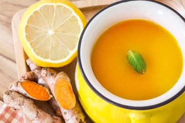 a cup of Turmeric Tea with lemon and ginger , Benefits for reduce Inflammation , Liver Detox and Cleanser healthy herb drink concept