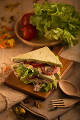 fresh made Tuna Sandwich on Wooden table in Golden Light. selective focus
