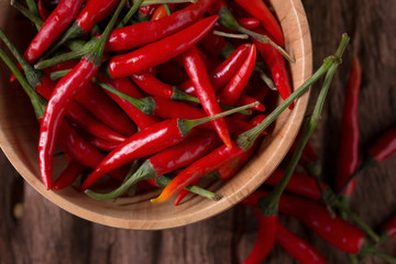 Red hot chili peppers in Wooden bowl on wooden background. Spicy chilli peppers