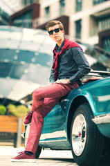 Fashion man standing near retro cabriolet car outdoors