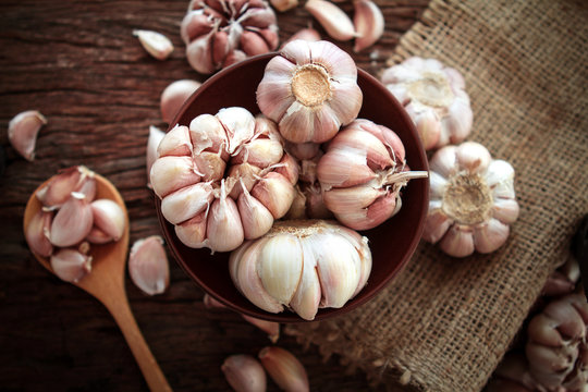 Close up garlic bulb in bowl on wooden table , top overhead shot