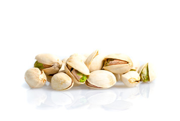 Roasted and salted pistachio nuts with shell with reflexion on white background