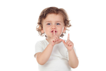 Cute baby has put forefinger to lips as sign of silence