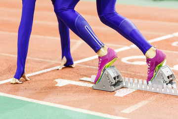 Sportswoman at the starting blocks before sprint running event