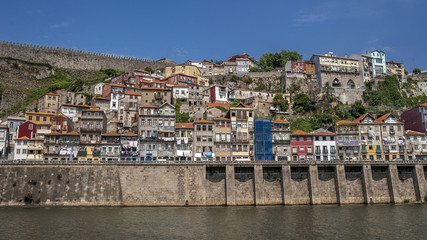 Fototapeta na wymiar Portugal , Porto, the embankment of Duero river , residential quarters of the old town , on the balconies drying clothes . The fortress wall .