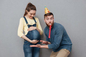 Portrait of a happy young family expecting child and celebrating