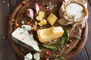 Fototapeta na wymiar Cheese delikatessen closeup on rustic wood, blue roquefort and parmesan