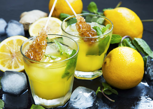 Fresh lemonade drinks glasses with mint leaves,lemons, ice cubes and sugar sticks