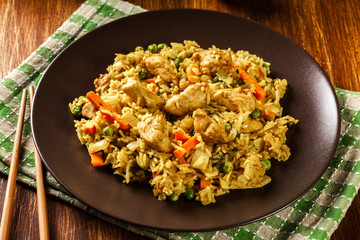 Fried rice nasi goreng with chicken and vegetables on a plate