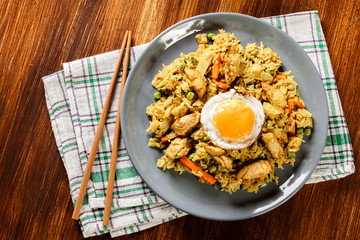 Naklejka premium Fried rice nasi goreng with chicken egg and vegetables on a plat