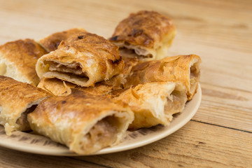Slices of apple pie on the plate over wooden table