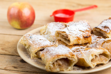 Apple pie sliced on the plate with powdered sugar