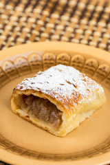 Apple pie sliced on the plate with powdered sugar