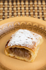 Apple pie sliced on the plate with powdered sugar