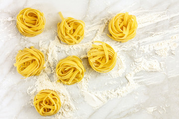 Overhead photo of pasta nests on white marble