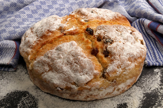 irish raisin soda bread with flour and kitchen towel