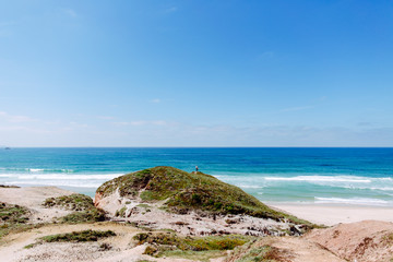 Mann mit Surfbrett an der Küste Portugals, Peniche, Baleal