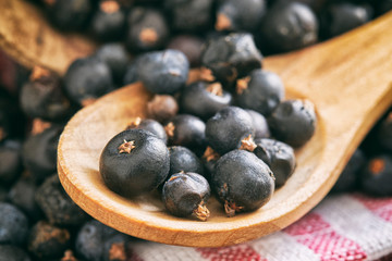 Close-up of dried juniper berries in wooden spoon