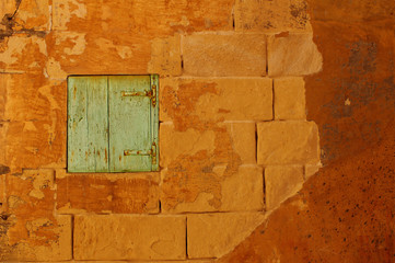 Ochre wall with rustic green wooden window