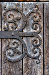 Ornate door.Rusty metal hinge of old wooden door. Isny im Allgau,Gemany