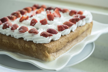 Closeup of Tres Leches cake decorated with strawberry and whipped cream