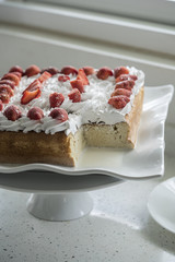 Closeup of Tres Leches cake decorated with strawberry and whipped cream