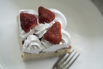Closeup of Tres Leches cake decorated with strawberry and whipped cream