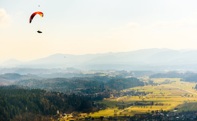 Paraglider is flying in the valley.