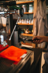 Espresso coffee grinder with the hands of a barista 