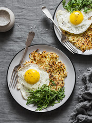 Hash Browns, fried egg and arugula on grey background, top view. Delicious simple lunch