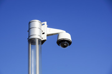 High tech overhead security camera with a blue sky