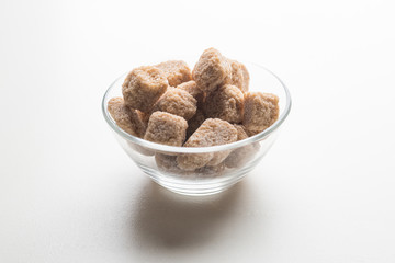Cane sugar cubes heap close up macro shot on white table