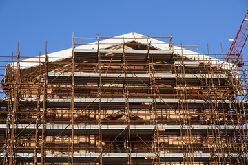 Extensive scaffolding providing platforms for work in progress on a church in restructuring
