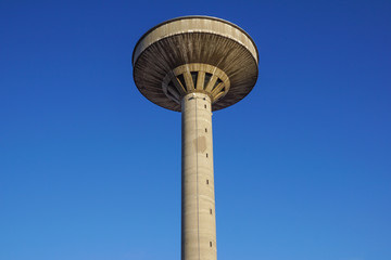 Fototapeta na wymiar concrete two water towers against blue sky