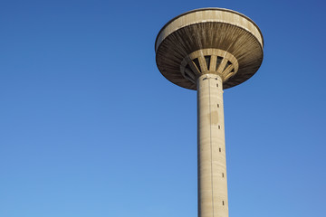 concrete two water towers against blue sky